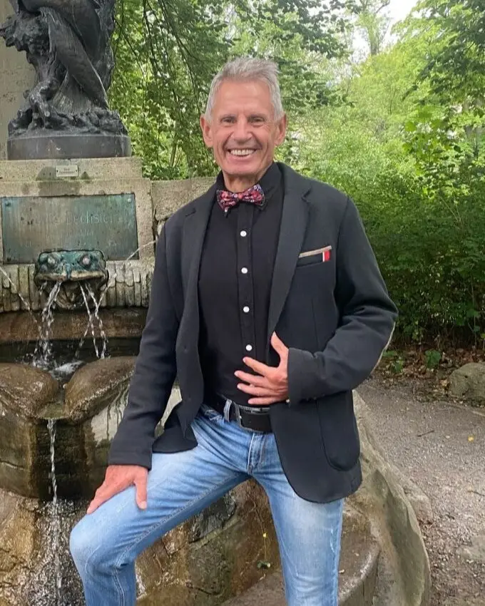 Ronald Dähne im Sakko an einem Brunnen im Park